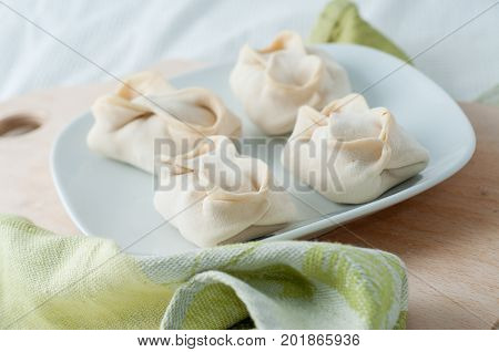 Frozen Dumplings On The White Plate With Green