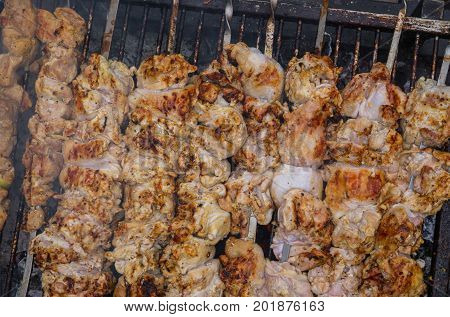 Preparation of a fresh delicious shish kebab from a chicken on skewers.