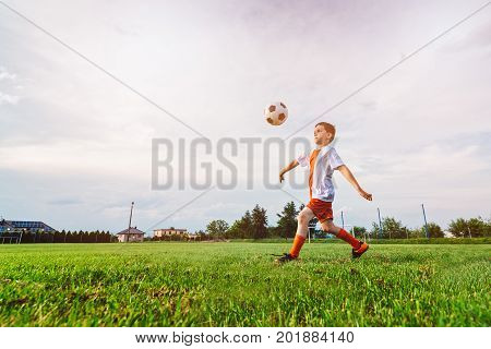 Boy Playing With Football Ball On Playing Field.