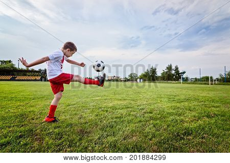 Boy Playing With Football Ball On Playing Field.