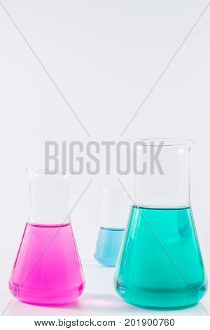 research, science and clinic background. 96 well micro plate and  laboratory beakers with colorful liquids and reagents.
