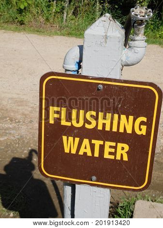 A flushable water station sign at a campground.