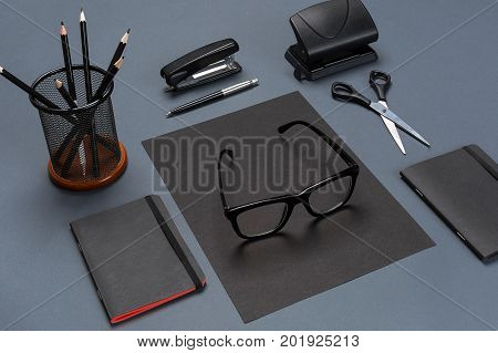 A set of black office accessories, glasses on gray background. Flat lay. Still life. Mock-up