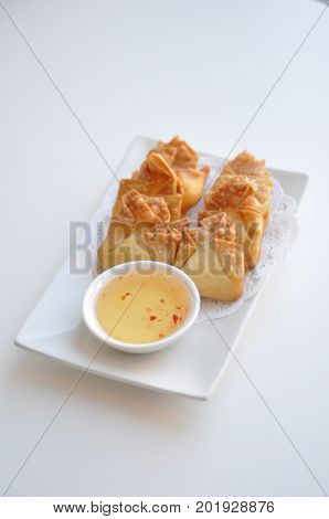Crab Rangoon. Cream cheese, crab-meat, celery wrapped in thin crape and fried. Served with light sweet & sour sauce.