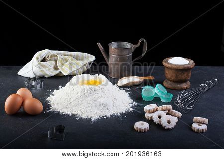 Flour eggs and canestrelli Italian shortbread cookies cooking utensils on table