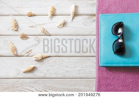 Bearch towel  and summer accessories on white wooden background. Travel concept. View from above. Blank mock up for advertising or packaging.