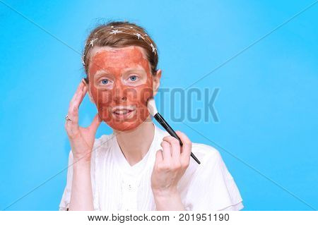 Young girl with mineral clay mask skincare treatment on her face