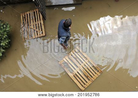 The consequences of flooding man in the water helping neighborhood