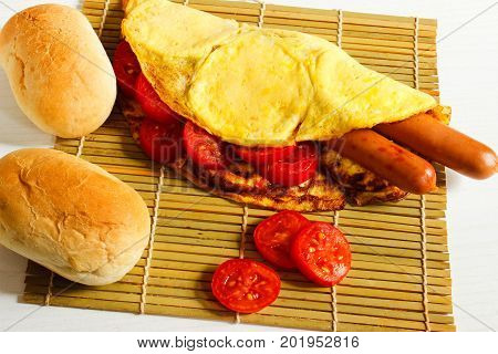 Breakfast of an omelette with sausages and coffee on a white wooden background