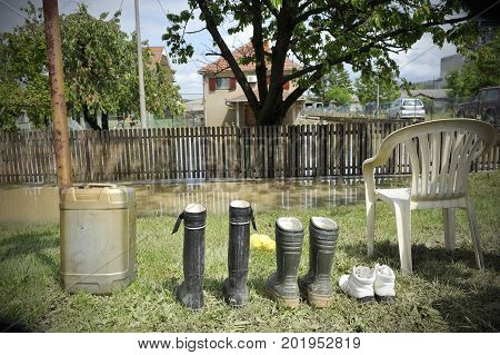 Concept photo of flooding. Waterproof rubber boots