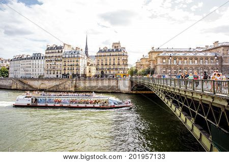 PARIS, FRANCE - August 07, 2017: View on the riverside with Arcole bridge and tourist boat in Paris