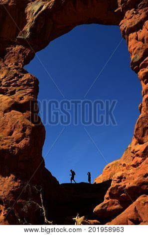 Silhouette of hiker in arch canyon rock formations