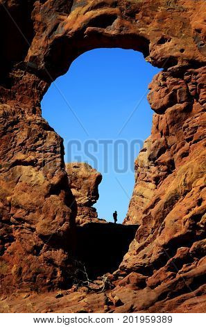 Silhouette of hiker in arch canyon rock formations