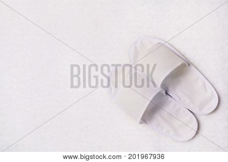 A pair of White Slippers on the white carpet