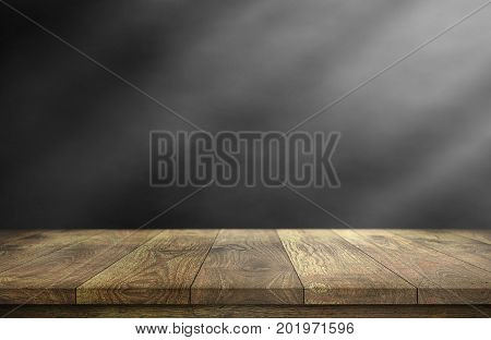 Old wood table with smoke in the dark background.
