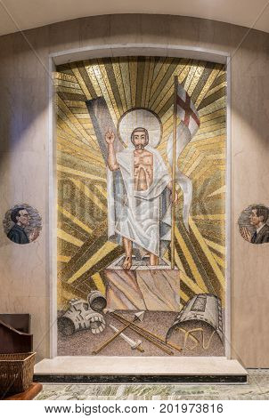 Galway Ireland - August 5 2017: Resurrection mosaic with side images of Patrick Pearse and John F. Kennedy in side chapel of Cathedral. Marble floor and wall. Jesus with flag stepping out of tomb. Weapons surrendered.