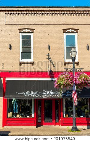 CHAGRIN FALLS OH - JULY 30 2017: A clothing storefront with a bright red facade and decorative awning adds to the charm of this Northeast Ohio village.