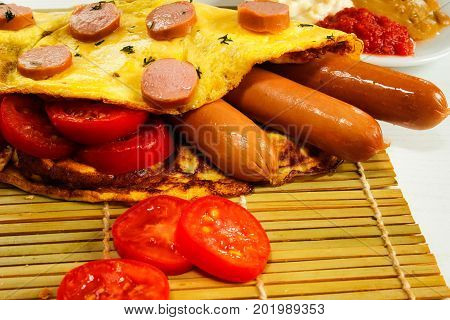 Breakfast of an omelette with sausages and coffee on a white wooden background