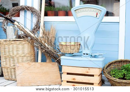 Wicker Baskets Next To The Garden Equipment Against The Wall Of A Blue Country House. Summer Seasona