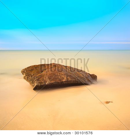 Flat Rock op een gouden strand. Lange blootstelling.