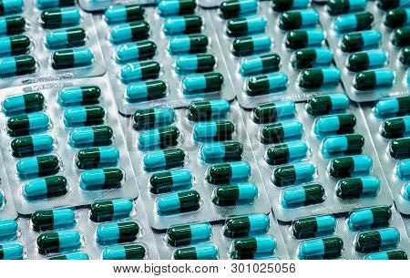 Amoxicillin Capsule In Blister Pack. Pharmaceutical Industry. Green-blue Antibiotic Capsule Pills. A
