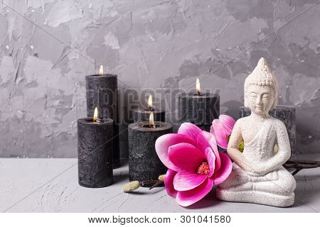 Black Burning Candles , Buddha And Pink Magnolia Flowers On Grey Textured Background. Spa Or Still L