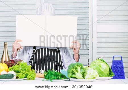 Man Chef In Hat And Apron Read Book. Culinary Recipes Book Concept. Improve Cooking Skill. Useful Bo