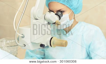 Pretty Doctor Woman Portrait. Ophthalmology Laser Microscope Operation. Clinic Room. Patient Eye Tre