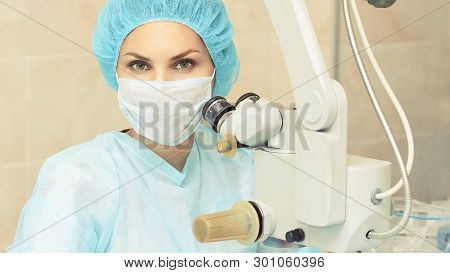 Pretty Doctor Woman Portrait. Ophthalmology Laser Microscope Operation. Clinic Room. Patient Eye Tre