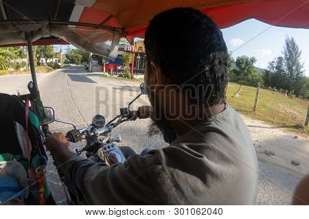 Phuket, Thailand - February 19, 2019: A Man With A Beard Is Driving A Moto Rickshaw  Or Tuk Tuk With