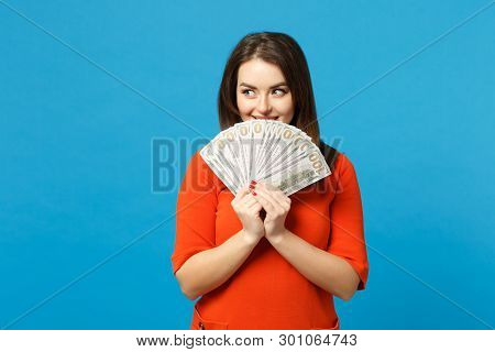 Beautiful Brunette Young Woman Wearing Red Orange Dress Holding Fan Of Cash Money In Dollar Banknote