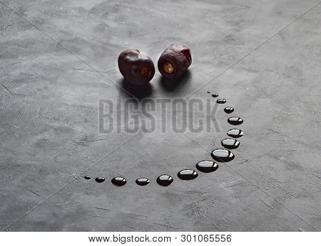 Black Ramadan Background With Dates And Dates Syrup Poured In The Shape Of Crescent Moon.