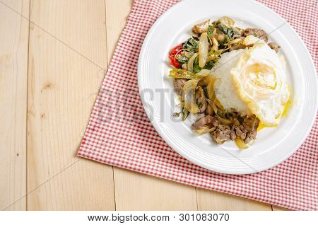 Fried rice with basil leaves and red cloth on the table.Ngredients of Basil Fried Chicken and fried 