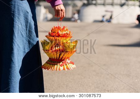 Nantou, Taiwan - FEB 8th, 2019: woman hold a lotus made by joss paper ready for burn at a Baohu Dimu Temple