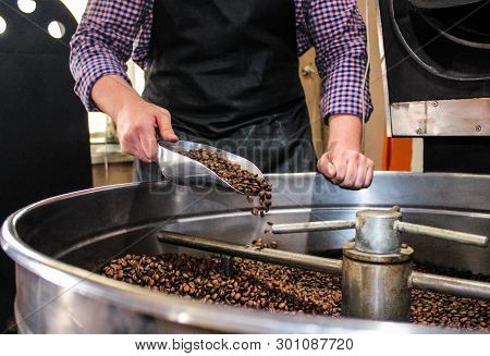 Man Working In The Production Of Roasting Coffee. Businessman Watching The Process Of Roasting Coffe