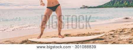 Surfing class at surf school on beach. Woman instruction giving class on how to stand on surfboard on shore before going in ocean water. Panoramic banner.