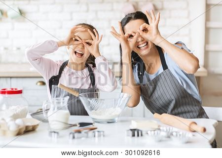 Cute Little Girl And Her Beautiful Mother Are Playing And Smiling While Baking In Kitchen At Home, F