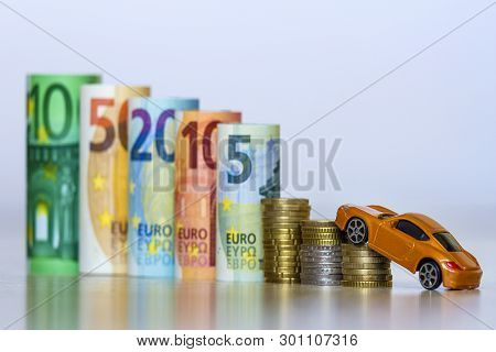 Blurred Row Of Rolled Hundred, Fifty, Twenty, Ten And Five New Euro Banknotes And Pile Of Coins With