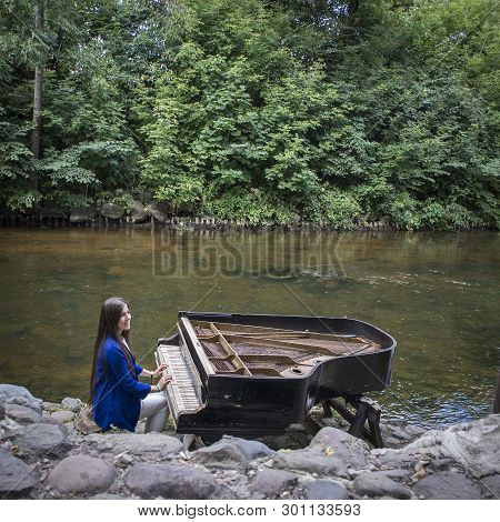 Abandoned Gran Piano, Rundown Piano By A River Bank (vilnia River) In Uzupis Artists Quarter In Viln