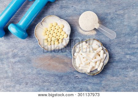 Collagen Powder, Proline Capsules And Vitamin C Tablets. Sports Supplements. Rustic Wooden Backgroun