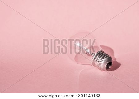 Close up view of white light bulb isolated on pink.