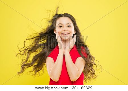 Girl Adorable Kid Long Wavy Hair Yellow Background. Wind Can Also Damage Hair. Strong Persistent Win