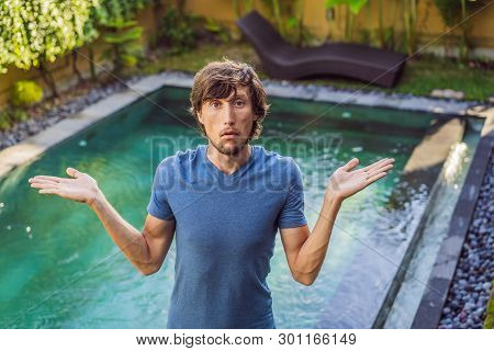 Man Chooses Chemicals For The Pool. Swimming Pool Service And Equipment With Chemical Cleaning Produ