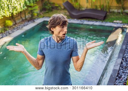 Man Chooses Chemicals For The Pool. Swimming Pool Service And Equipment With Chemical Cleaning Produ