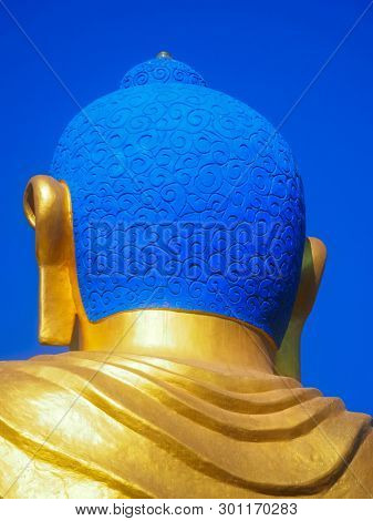Closeup vibrant blue Shanti Ban Buddha head, 25 feet tall golden Buddha's image on a sunny day in Dhulikhel, Nepal 