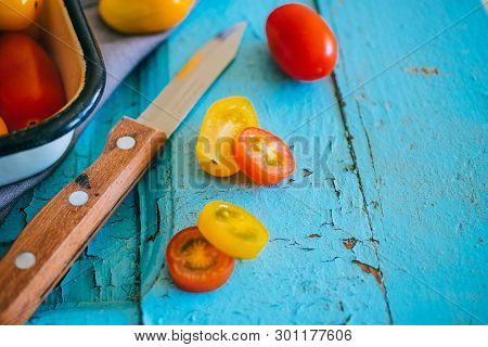Small Cherry Tomatoes, Red And Yellow On A Blue Background