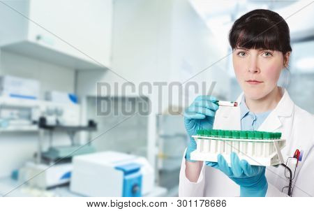 Female Young Doctor-intern, Tech Or A Scientist With Blood Test Tubes In Medical Or Research Facilit