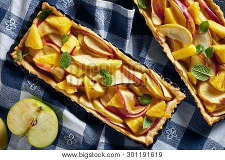 Close-up Of Delicious Pineapple And Apple Sweet Tarts  In Rectangular Tart Pans On A Concrete Table 