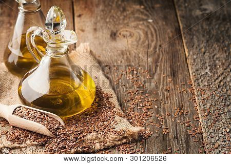 Flax Seeds And Linseed Oil In A Glass Jug On A Wooden Table, Healthy Diet With Omega 3 Fatty Acids