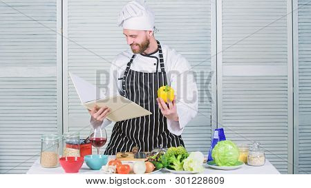 According To Recipe. Man Bearded Chef Cooking Food. Guy Read Book Recipes. Culinary Arts Concept. Ma